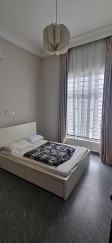a bed in a bedroom with a large window at The white house in Douala