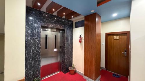 a hallway with a brick wall and a door at Hotel Janmabhumi in Pashupatināth