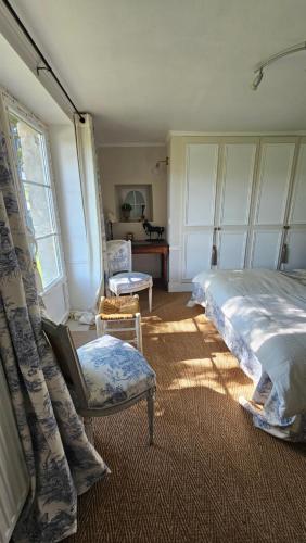 a bedroom with a bed and a chair and a desk at L'Orée d'Ermenonville in Borest