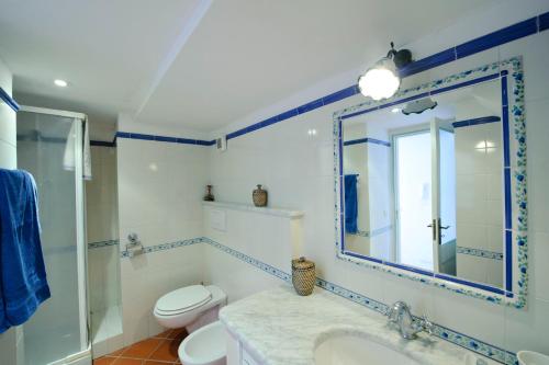 a bathroom with a sink and a toilet and a mirror at Casa Elena in Praiano