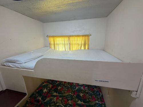 a bunk bed in a small room with a window at Maria Kulafu Lodging House Pier site- Santa Clara office 2nd Floor in Cagba