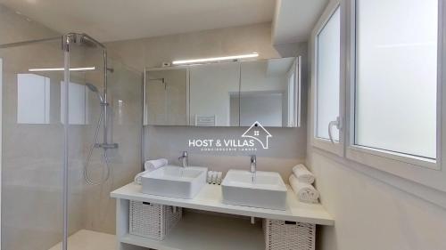 a bathroom with two sinks and a shower at Host Villas LA TIRMANAISE Capbreton in Capbreton