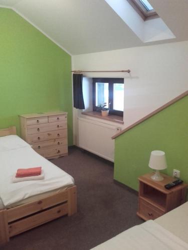 ein Schlafzimmer mit grünen Wänden, einem Bett und einem Fenster in der Unterkunft Hotel Anna in Harrachov