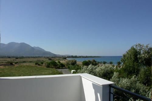 a white balcony with a view of the water at Studios Akrogiali in Kyparissia
