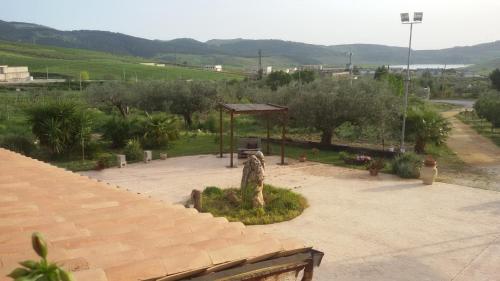 a garden with a bench and a gazebo at Antico Frantoio Rooms in Sambuca di Sicilia