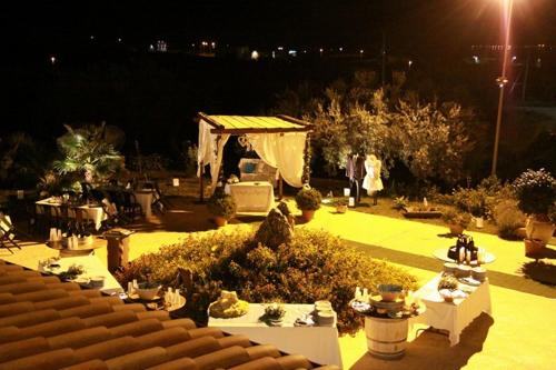 a night view of a garden with tables and plants at Antico Frantoio Rooms in Sambuca di Sicilia