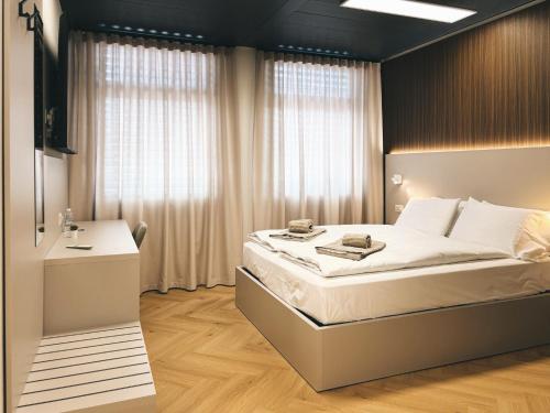 a bedroom with a large bed and a desk at B-ROOMS Bleisure Hotel - Lugano district in Manno