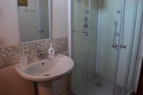 a bathroom with a sink and a shower at Antico Frantoio Rooms in Sambuca di Sicilia