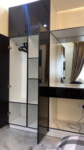 a large glass cabinet with shelves in a room at Crystal Apartment in Ofada