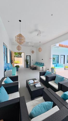 a living room with couches and blue pillows at LVIS Pool Villa in Dharavandhoo