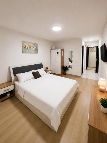 a bedroom with a large white bed and a television at Nicolle Elite Apartment in Piteşti