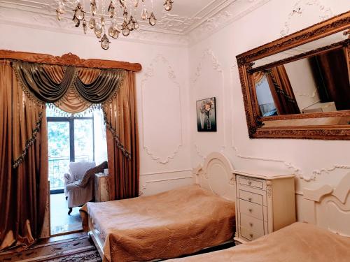 a bedroom with two beds and a mirror at Hotel Royal in Kutaisi