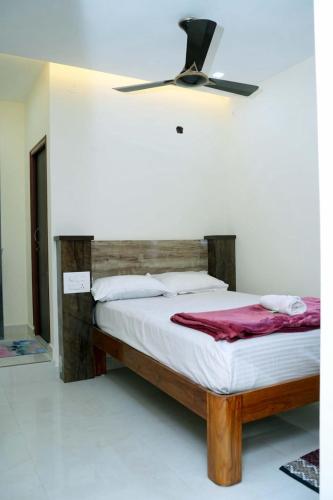 a bedroom with a bed with a ceiling fan at VS Residency in Elūru