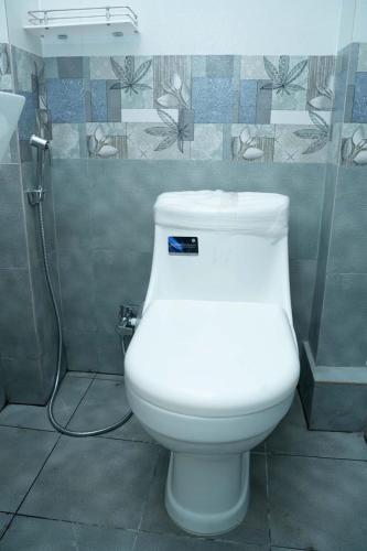 a white toilet in a bathroom with a shower at VS Residency in Elūru