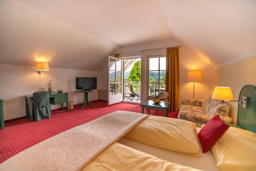 a bedroom with a large bed and a living room at Hotel Drachenwand-Mondsee in Mondsee