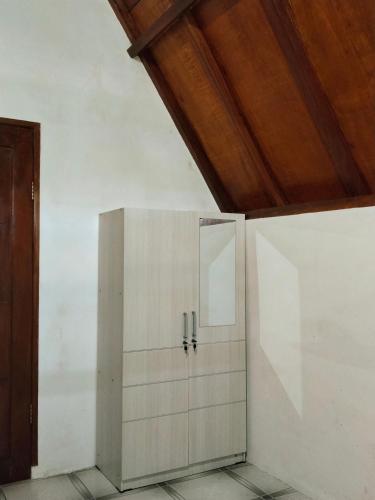 a white cabinet in a room with a wooden ceiling at Nan Bungalows Tetebatu in Tetebatu