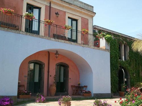 a building with an archway and flowers on it at Etna Hotel in Giarre