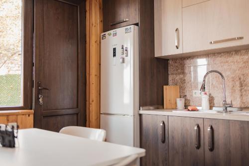 a kitchen with a white refrigerator and wooden cabinets at Bethlehem Terrace in Tbilisi City
