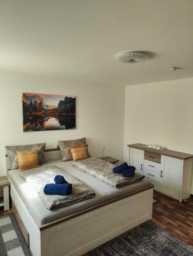 a bedroom with a large bed with blue pillows on it at Apfelhof Rüdersdorf in Rüdersdorf