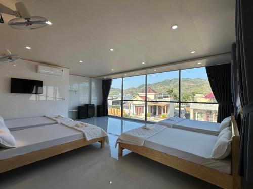 a bedroom with two beds and a large window at Motel Mỹ Linh 976 in Long Hai