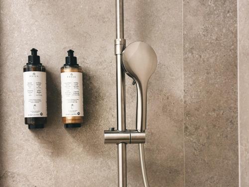 two bottles and a spoon on a wall at B-ROOMS Bleisure Hotel - Lugano district in Manno