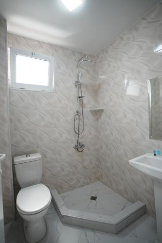 a white bathroom with a toilet and a sink at Toma Palace in Makhinjauri