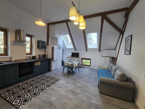 a living room with a blue couch and a kitchen at Barn - Nocleg na Mazurach in Sołtmany
