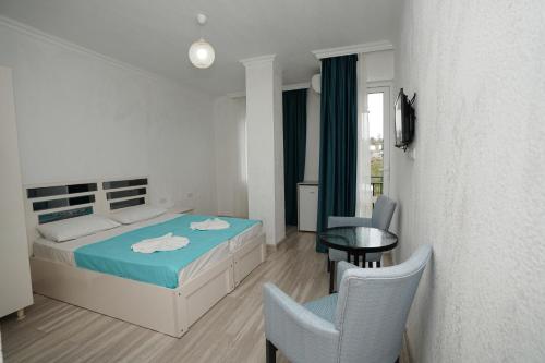 a bedroom with a bed and a table and chairs at Toma Palace in Makhinjauri