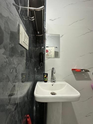 a bathroom with a white sink and a mirror at SS Hostel in Siliguri