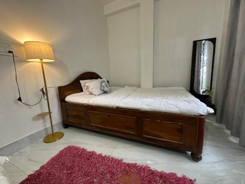 a bedroom with a bed with a lamp and a red rug at SS Hostel in Siliguri