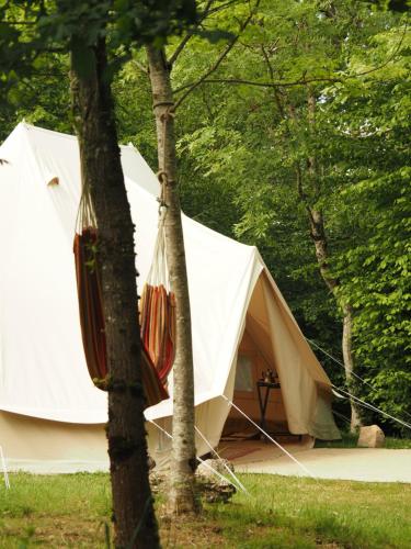 a large white tent sitting next to two trees at Glamping Tent Celte du Morvan, Vrij in de Natuur in La Tagnière