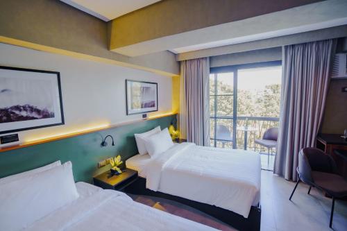ein Hotelzimmer mit zwei Betten und Balkon in der Unterkunft Venus Parkview Hotel in Baguio City