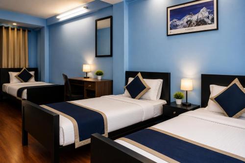 two beds in a room with blue walls at Second Home Hotel in Kathmandu