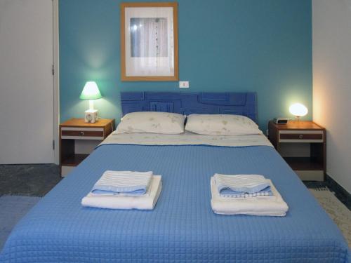 a bedroom with a blue bed with towels on it at Holiday Home Pescara in Pescara