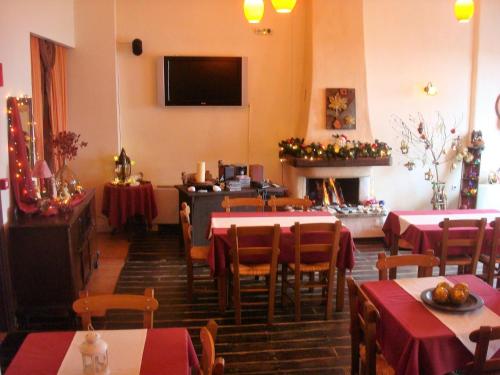 a dining room with tables and chairs and a fireplace at Guesthouse Amanitis Caesarea in Skíti
