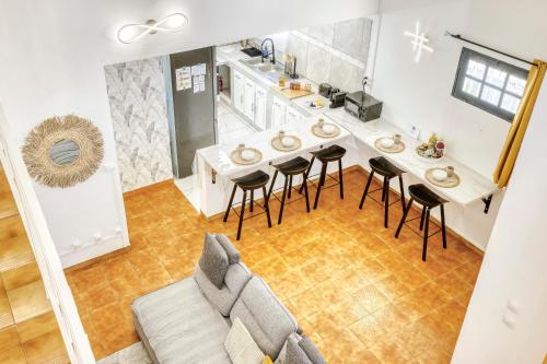 a living room with a couch and a table and chairs at La Villa Des Lys avec jacuzzi in Saint-Denis