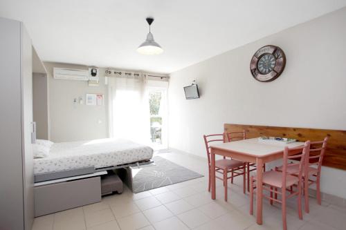 Le Champ d'Eysson Aparthotel في مونتورو: غرفة نوم مع طاولة وكراسي وسرير