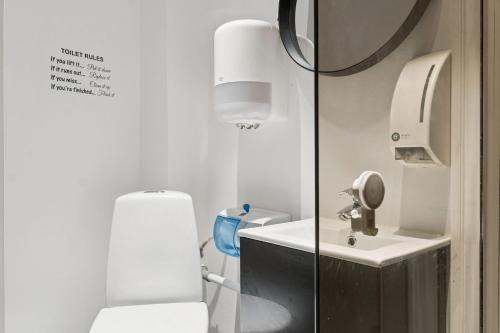 a bathroom with a white toilet and a sink at John F Kennedys Suite in Aalborg