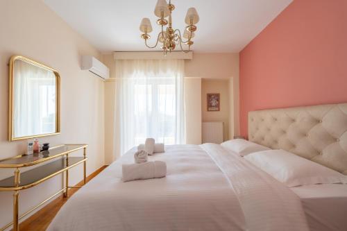 a bedroom with a large white bed with a chandelier at Apartments Nina in Athens