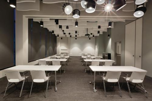 a classroom with white tables and chairs and lights at Radisson Red Minneapolis Downtown in Minneapolis