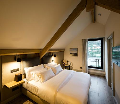 um quarto com uma cama grande e uma janela grande em Quinta de S.Bernardo - Winery & Farmhouse em Mesão Frio