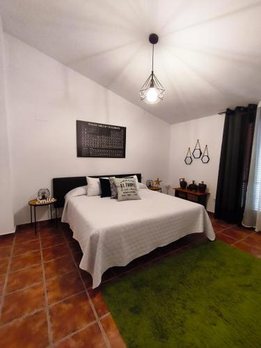 a bedroom with a white bed and a green rug at El Torreón in Valderredible