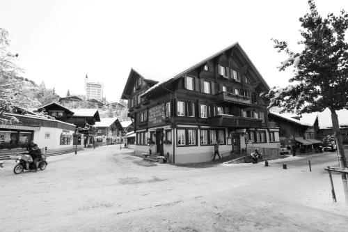 an old black and white photo of a building at Posthotel Rössli in Gstaad