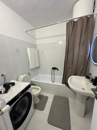 a bathroom with a washing machine in a washer at AirbnbTzo in Perístasis