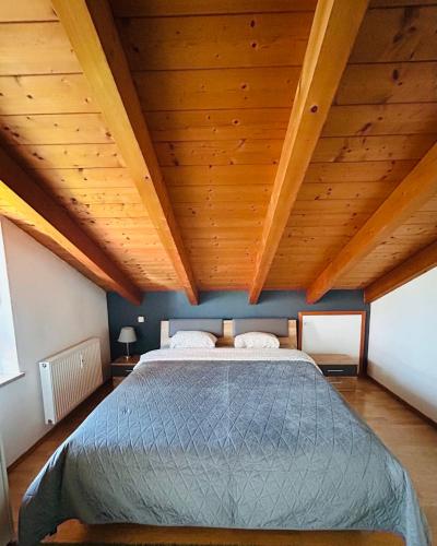 a bedroom with a large bed with a wooden ceiling at Staufen Blick in Piding