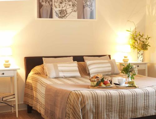 a bed with a tray of food on top of it at Logis Hotel Restaurant LA BARGUILLERE in Saint-Pierre-de-Rivière