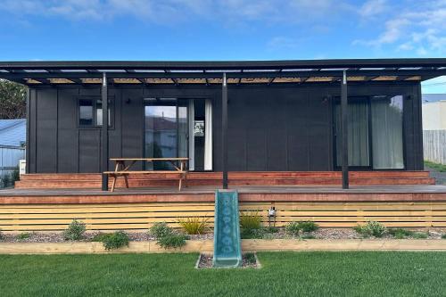 a black house with a sign in front of it at Settlers Nook Oamaru in Oamaru