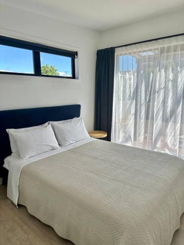 a bedroom with a large bed and a window at Settlers Nook Oamaru in Oamaru