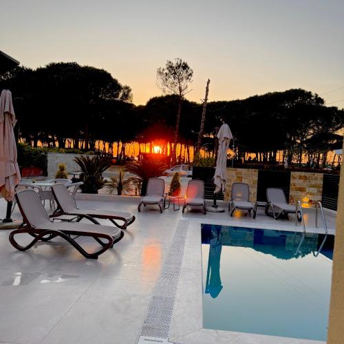 a pool with chairs and umbrellas and a group ofitures at Swiss Villa Qerret in Golem
