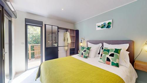 a bedroom with a large bed with yellow and green pillows at Casa Dina in Sommières
